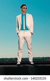 Retro Fifties Summer Fashion Man With White Suit And Sunglasses. On Rooftop. Blue Sky.