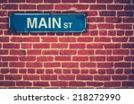 Retro Filtered Photo Of A Main Street Sign On A Red Brick Wall