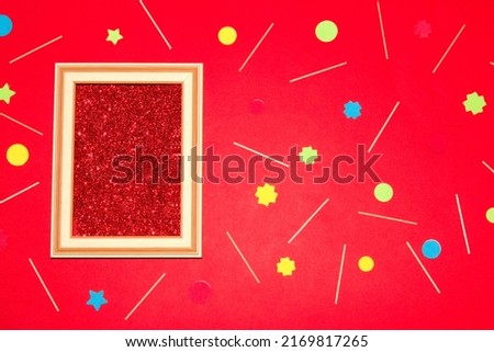 retro frame with glitter red wallpaper as copy space, around the frame red wallpaper with sticks and colorful geometric shape, creative art wallpaper