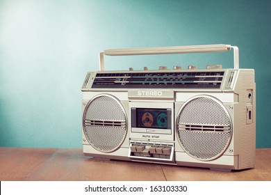 Retro ghetto blaster cassette tape recorder on table in front mint green background