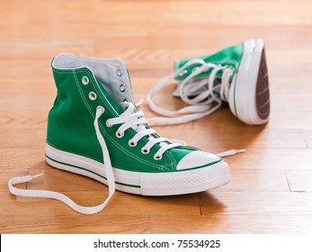 Retro green sneakers left on wooden floor - Powered by Shutterstock