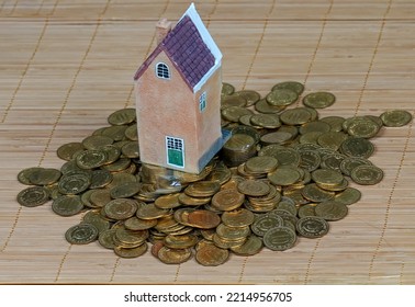 Retro House Model Standing On Pile Of Gold Coins Presenting Buying First House