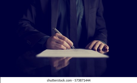 Retro image of businessman signing document or contract with silver pen on a black desk with reflection. - Powered by Shutterstock