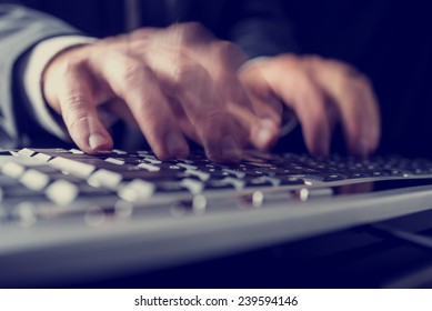 Retro image of a businessman typing on a computer keyboard inputting data with motion blur.