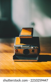 Retro instant camera on a midcentury wooden desk. Polaroid. High quality photo