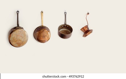 Retro kitchen utensils hanging on a hooks. Old style accessories copper saucepan colander coffee maker. copy space