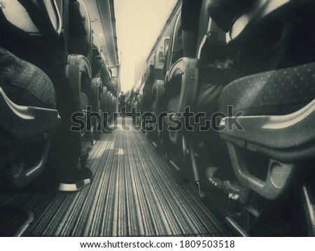 retro look of a passenger plane cabin aisle with feets of passengers