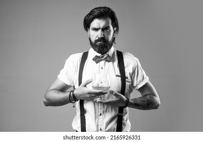 retro man in bow tie relaxing with alcohol. confident elegant bartender in classical wear drinking brandy. masculinity and charisma. whiskey and scotch. old fashioned bearded barman