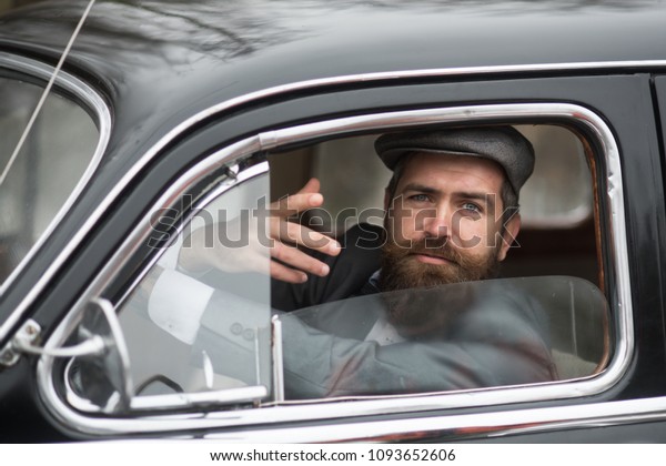 Retro man\
in retro car showing communicative\
gesture