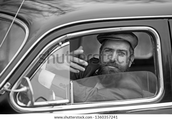 Retro man
in retro car showing communicative
gesture