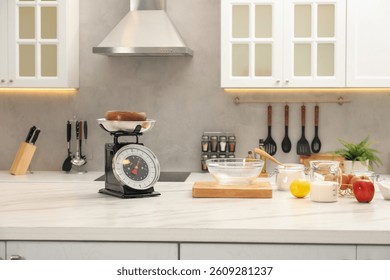 Retro mechanical kitchen scale and different food products on white marble table indoors