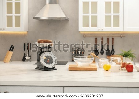 Retro mechanical kitchen scale and different food products on white marble table indoors