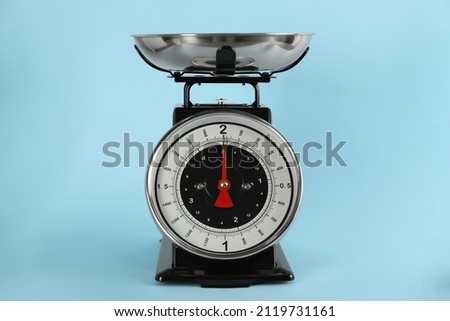 Retro mechanical kitchen scale on light blue background