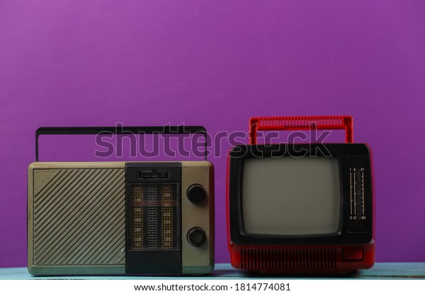 Retro media. Old portable tv, radio receiver\
on a purple background