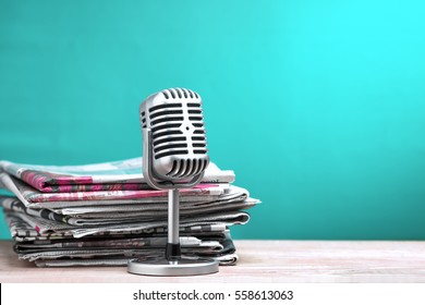 Retro microphone with newspaper on wooden table - announcement concept