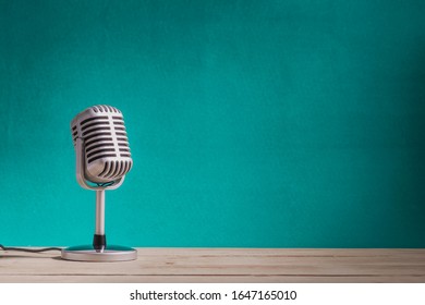 Retro-Mikrofon auf Holztisch mit grünem Hintergrund