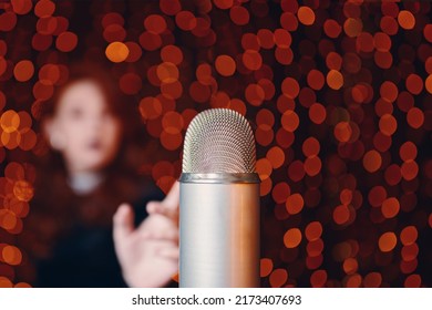 Retro microphone and silhouette of woman on blurry bokeh background. Performance of female singer in black dress at concert. Close up with copy space. - Powered by Shutterstock