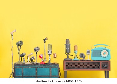 Retro mint blue radio, classic microphones for press conference or interview on wooden TV stand and old case front yellow background. Vintage style filtered photo - Shutterstock ID 2149951775