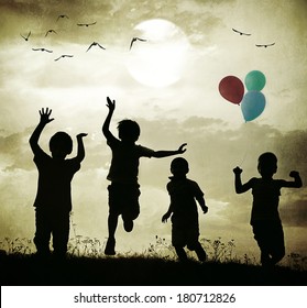 Retro old fashioned photo of children with balloons running on summer meadow