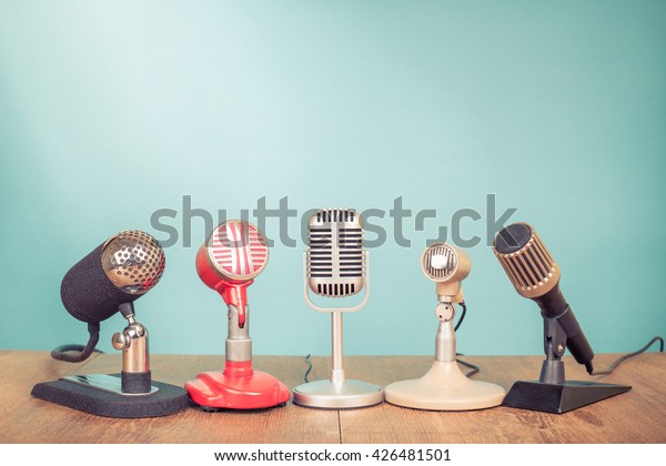 Retro old microphones for press\
conference or interview on table. Vintage style filtered\
photo