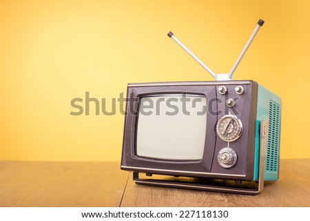 Retro old portable television from 80s front gradient yellow background