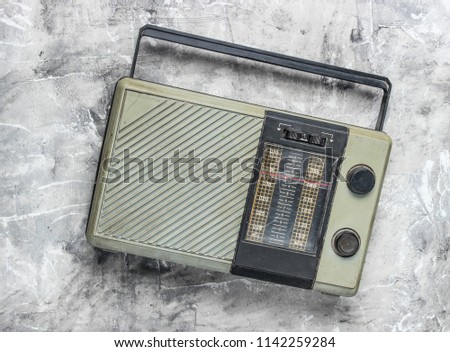 Retro old radio receiver on a gray concrete background. Top view. Outdated technology
