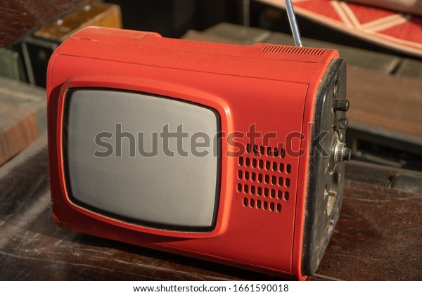 Retro Old Red Plastic Body TV Set Reciever On\
Wooden Table