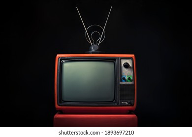 Retro Old Red TV With Antenna On Wooden Box On Black Background