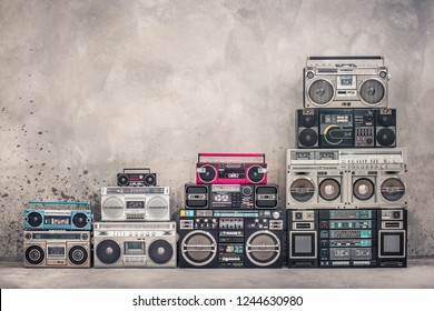 Retro old school design ghetto blaster boombox stereo radio cassette tape recorders tower from circa 1980s front aged concrete wall background. Vintage style filtered photo