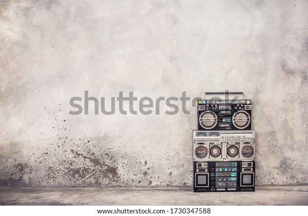 Retro old school design ghetto blaster boombox\
stereo radio cassette tape recorders from 80s front concrete wall\
background. Nostalgic Rap, Hip Hop, R&B music concept. Vintage\
style filtered photo