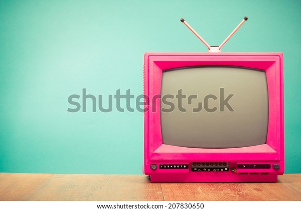 Retro old television from 80s front mint green\
wall background