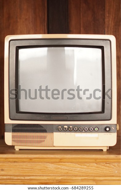 Retro old television in vintage wooden wall
brown background.