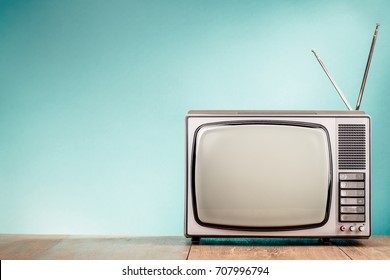 Retro old TV receiver on the table front gradient aquamarine wall background. Vintage style filtered photo - Shutterstock ID 707996794
