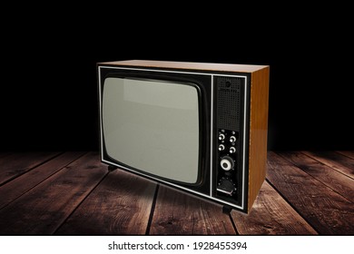 Retro Old TV Standing In A Dark Room On Wooden Desk