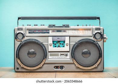 Retro outdated portable cassette tape recorder from 80s on wooden table front mint blue wall background. Vintage old style filtered photo - Shutterstock ID 2063348666