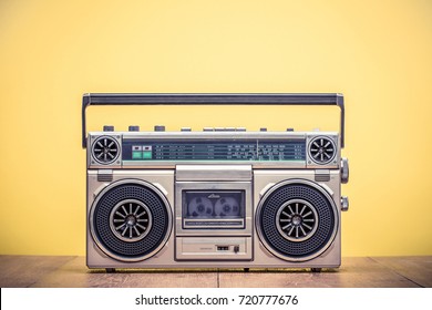 Retro outdated portable stereo boombox radio cassette recorder from 80s front yellow background. Vintage instagram old style filtered photo - Shutterstock ID 720777676