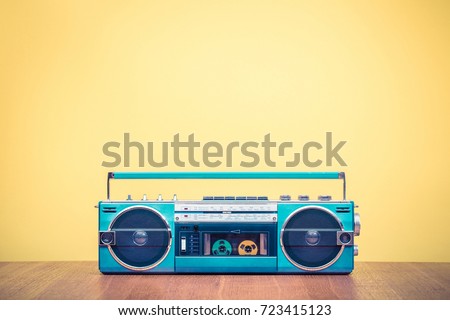 Retro outdated portable stereo mint green radio cassette recorder from 80s front yellow background. Vintage old style filtered photo