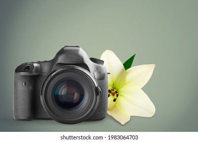 Retro Photo Camera On A Desk Near Flowers.