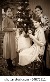 Retro Photo Of  Daughters With Mother Decorating Christmas Tree At Home