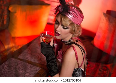 Retro portrait of a beautiful Gatsby woman with a martini glass. Vogue fashion style and smoke
