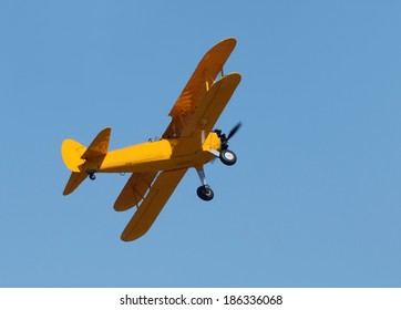 Retro propeller airplane in flight painted yellow