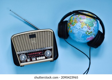 Retro radio, headphones and globe on blue background. World radio day. world music day. Top view, flat lay, top view