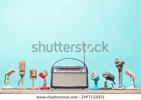Retro radio and old microphones for press conference or interview on table front gradient aquamarine background. Vintage old style filtered photo