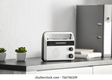 Retro radio receiver on office cabinet - Shutterstock ID 766746109