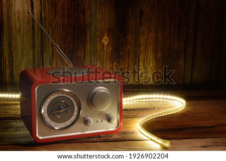 retro radio receiver on a wooden table next to a glowing garland.selective focus.