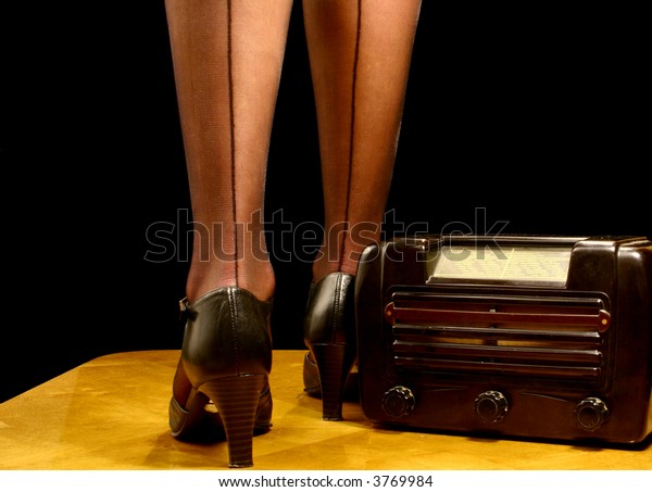 Retro radio set together with beautiful legs and\
high-heeled shoes