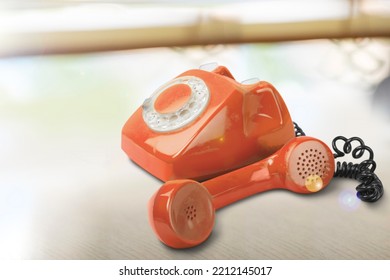 A Retro Red Old Telephone On A Table.