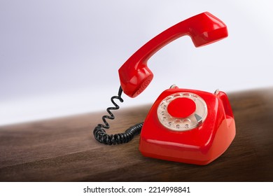 A Retro Red Old Telephone On A Table.