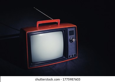 Retro Red Old TV With Antenna In Dark Room, Vintage Television On Black Floor.