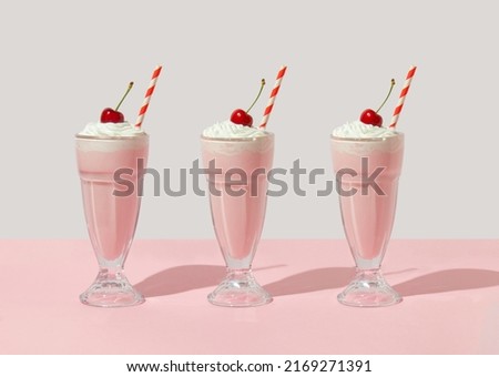 Retro romantic creative pattern with strawberry milkshake with cherry on top on white and pastel pink background. 70s, 80s or 90s retro fashion aesthetic idea. Valentines day romantic idea.